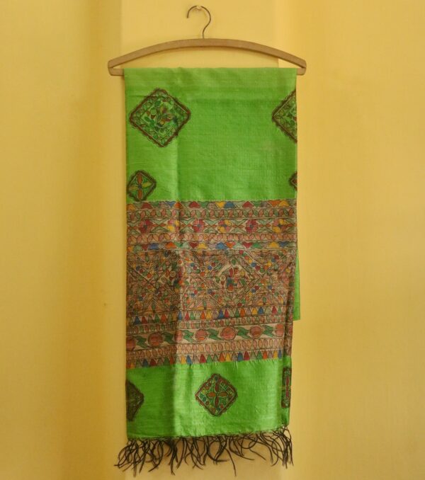 The Emerald Heritage Dupatta brings to life classic Madhubani artistry on a radiant green silk base. Featuring intricate hand-painted motifs framed in geometric borders, this piece is both a celebration of culture and a statement of style. Highlights: ● Lush green silk with handpainted Madhubani art ● Vibrant geometric and floral motifs in natural tones ● Elegant tassels for a graceful finish ● Handpainted to perfection by rural artisans Dimensions: ● Length: 97.5 inches ● Width: 35 inches Material: Blended Silk with Fabric Paint